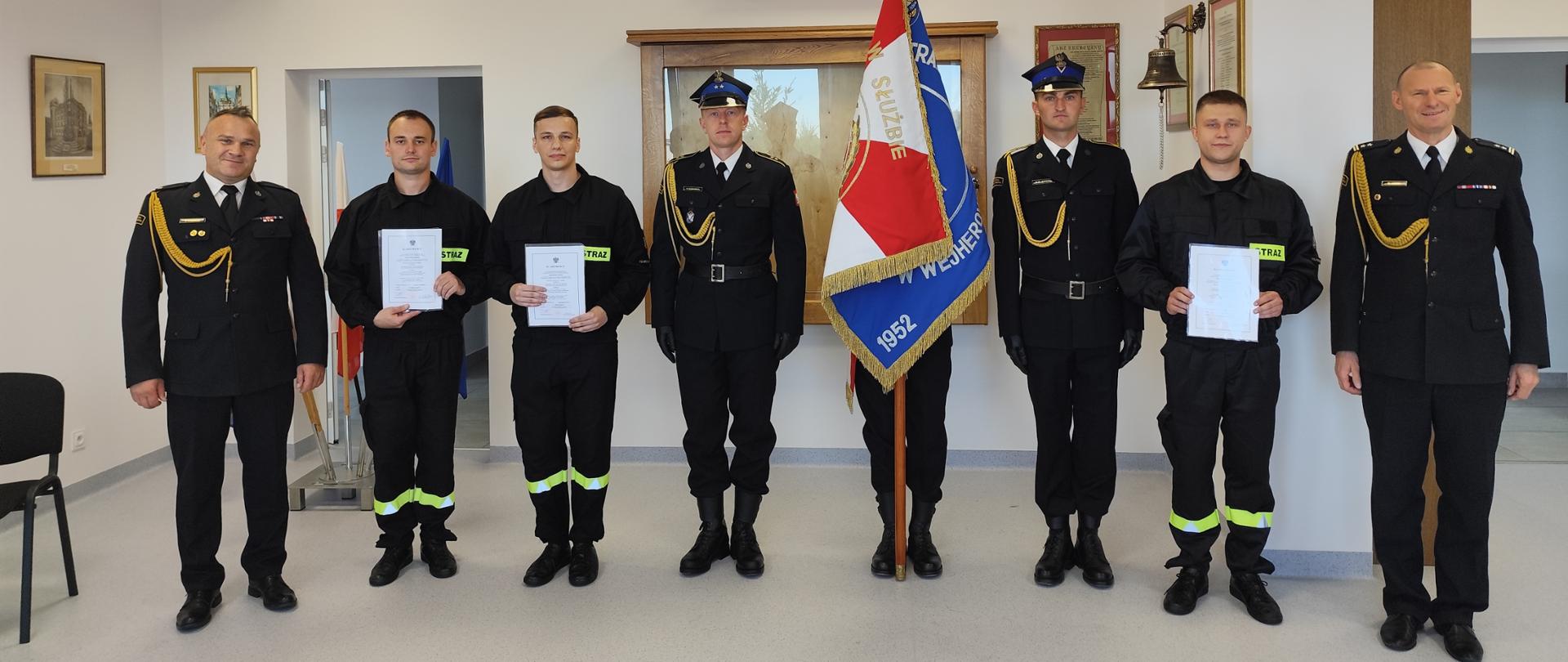 Na zdjęciu znajduje się kierownictwo PSP wraz ze sztandarem i nowo zatrudnionymi funkcjonariuszami.