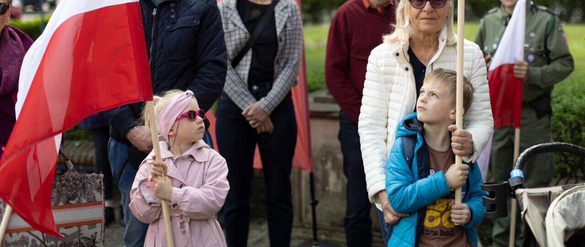 dwoje dzieci trzyma flagę biało czerwoną
