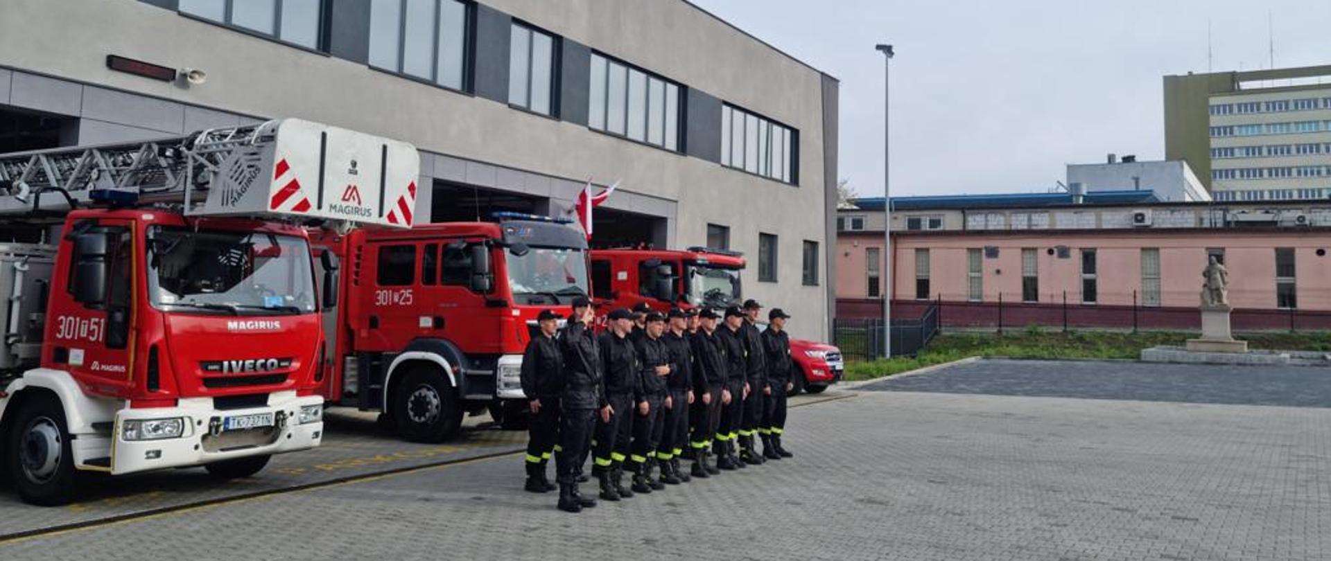Zdjęcie strażaków podczas śpiewania hymnu przy budynku Jednostki Ratowniczo-Gaśniczej nr 1 w Kielcach.