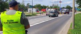 Funkcjonariusz zabezpiecza miejsce kolizji