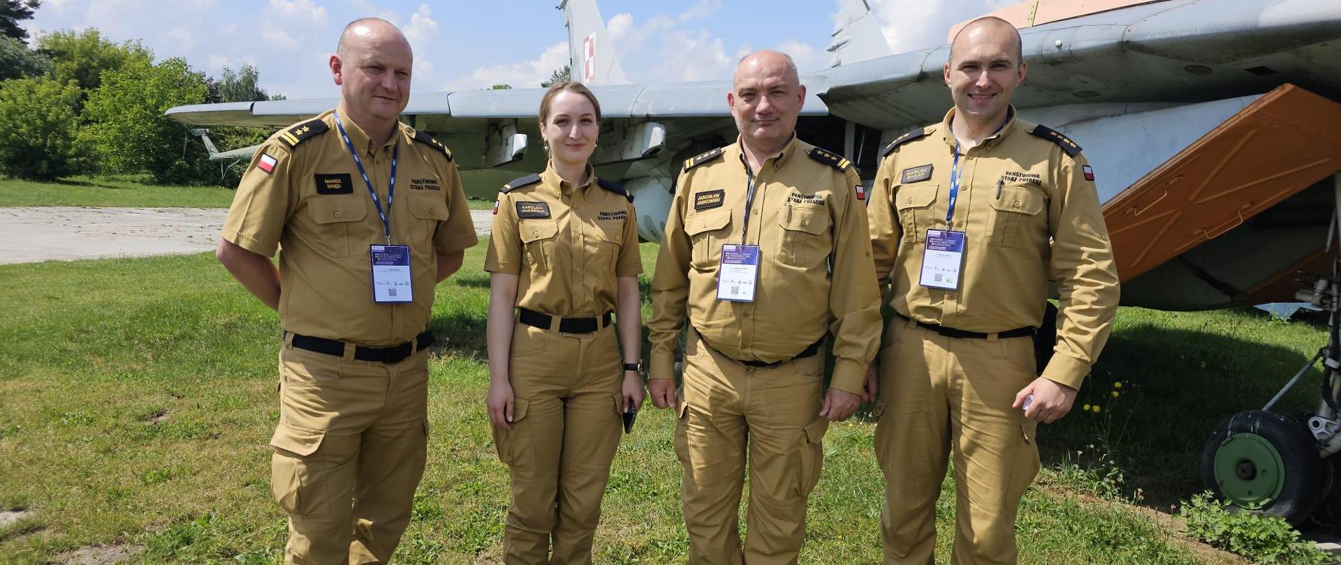 Pamiątkowe zdjęcie Komendanta Centralnej Szkoły PSP stojącego wspólnie z trojgiem strażaków