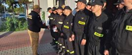 Zdjęcie przedstawia strażaków stojących w dwuszeregu podczas uroczystej zbiórki z okazji wręczenia nagród ministra. 