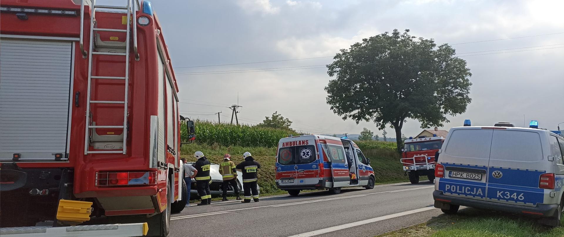 Na zdjęciu widoczne są pojazdy służb: Policja, Straż Pożarna, Zespół ratownictwa medycznego oraz funkcjonariusze prowadzący swoje czynności służbowe
