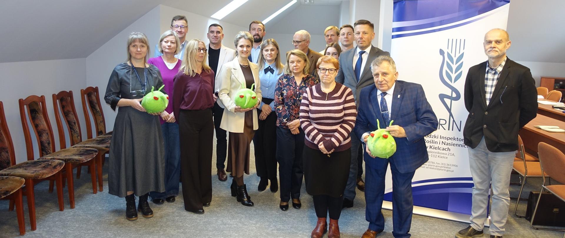 Zdjęcie przedstawia Wojewódzkiego Inspektora wraz ze swoim zastępą oraz kierowników Działów i Oddziałów. Na fotografii widoczne są też agrofagi Pesty 