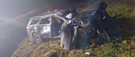 Na zdjęciu widoczny jest zniszczony pojazd osobowy, który podczas zdarzenia wypadł z drogi. Pojazd jest w całości zniszczony poprzez swoje uszkodzenia i liczne wgniecenia.