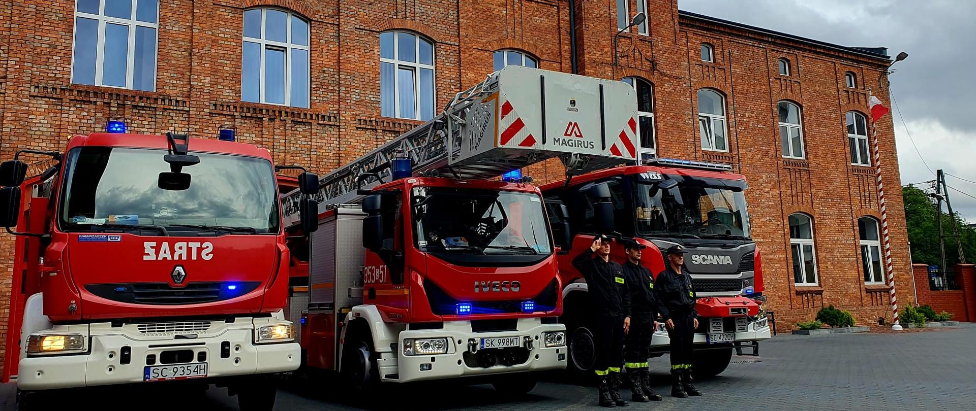 Na zdjęciu przed budynkiem Jednostki Ratowniczo-Gaśniczej numer 3 w Częstochowie ustawione samochody pożarnicze przed nimi ustawieni strażacy w umundurowaniu koszarowym oddają hołd powstańcom.