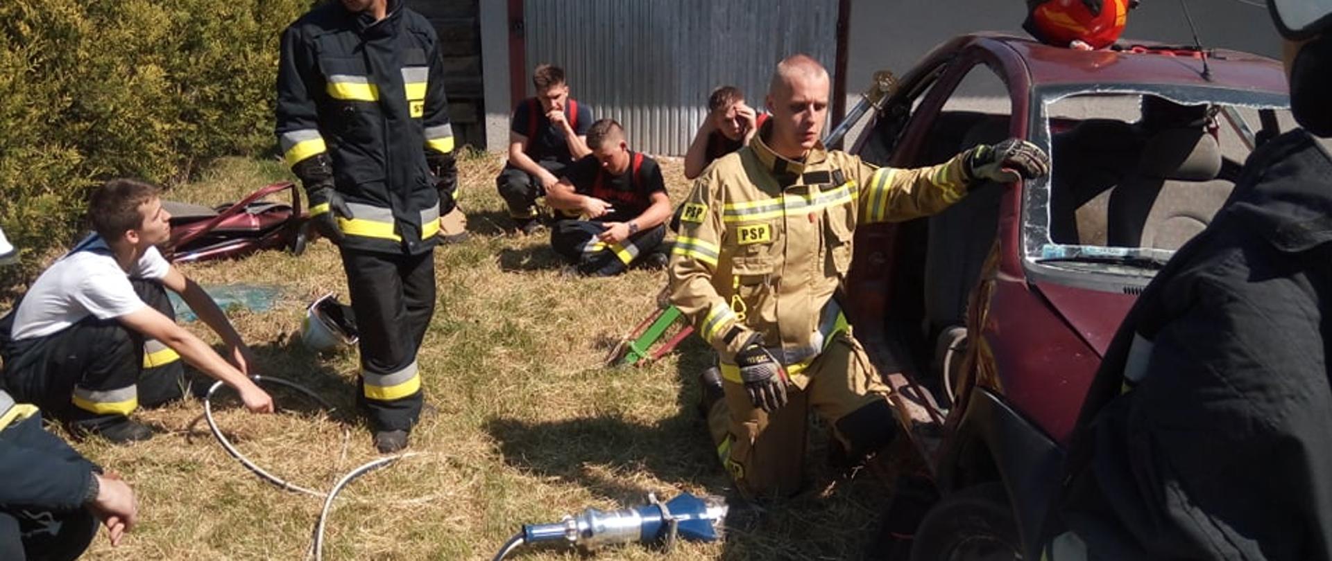Wrak samochodu, strażacy dookoła, prowadzący na środku