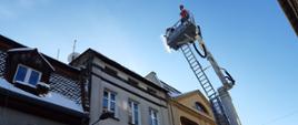 straż usuwa śnieg z dachu kamienicy