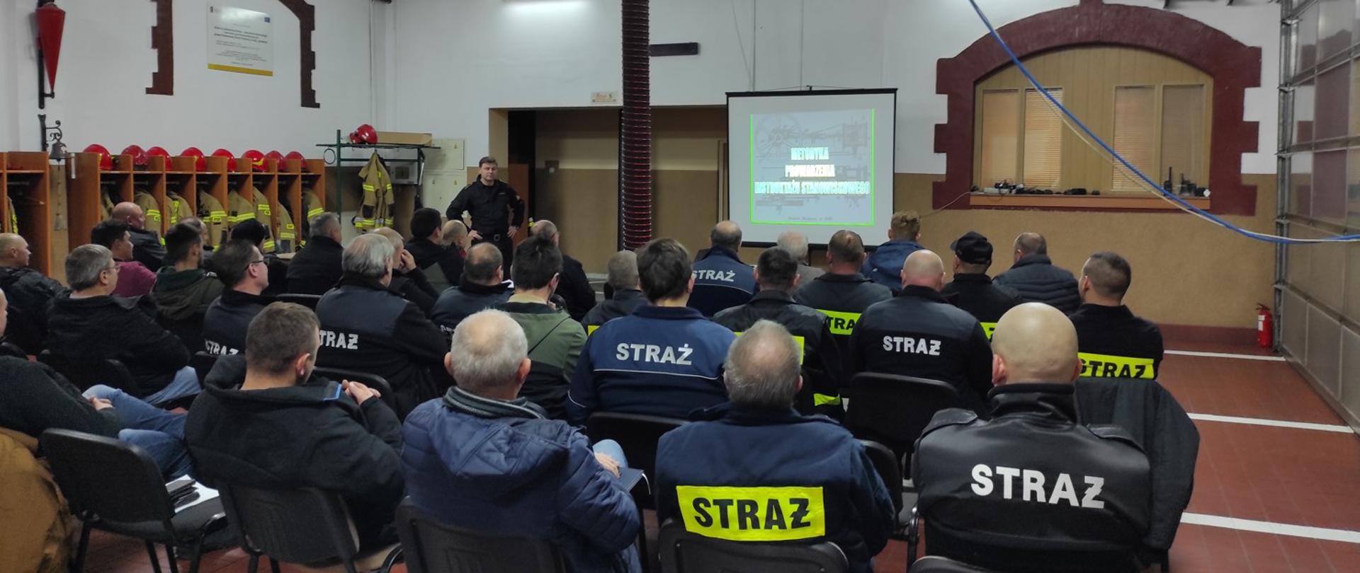 Zdjęcie przedstawia strażaków OSP podczas szkolenia w garażu komendy powiatowej PSP