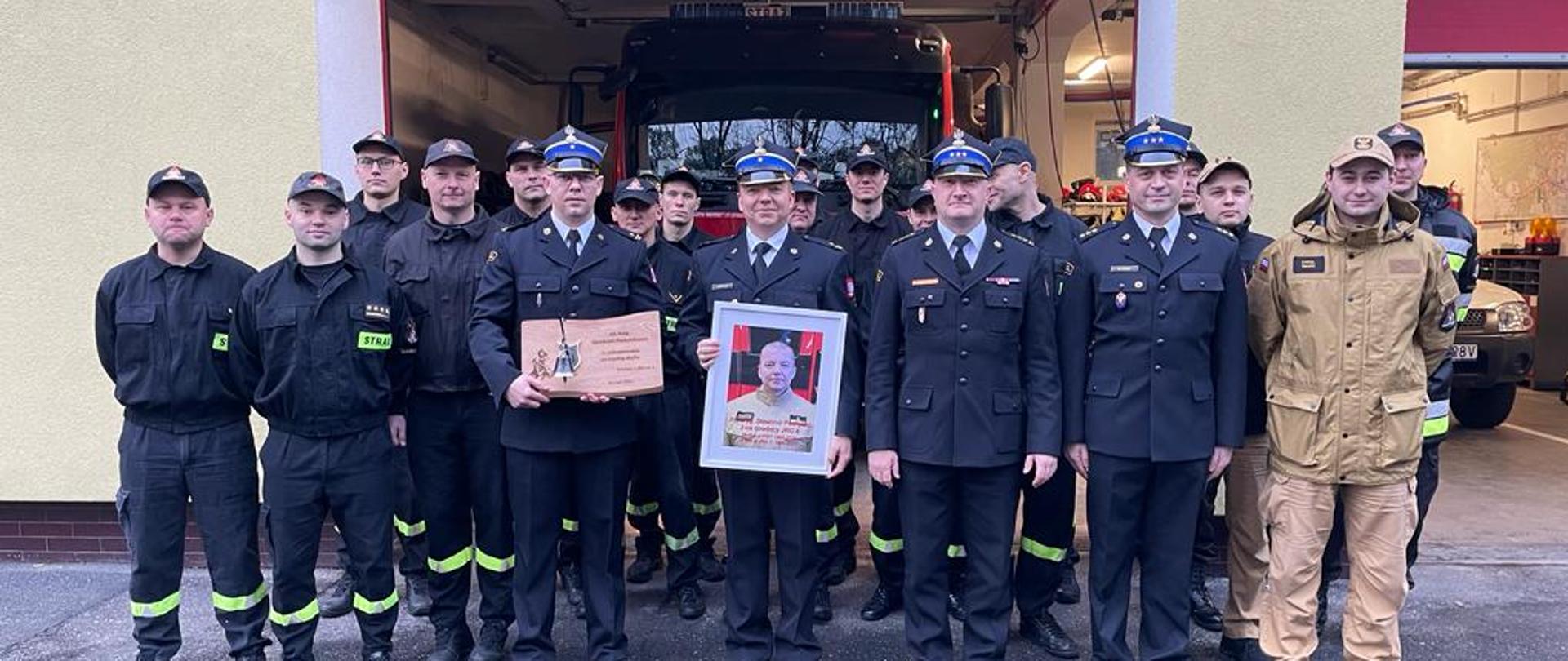 Strażacy biorący udział w uroczystości w zdjęciu grupowym