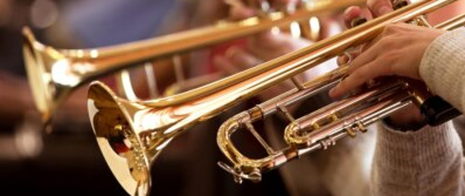 Zdjęcie przedstawiające muzyków grających na trąbkach