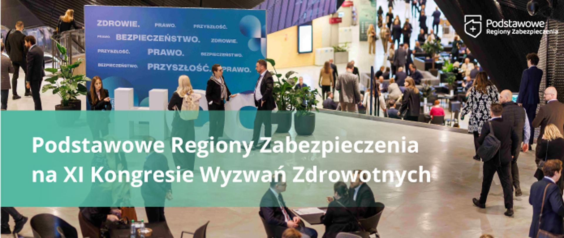 Uczestnicy konferencji w przestrzeni targowo-kongresowej, z widoczną strefą wystawienniczą i banerem „Podstawowe Regiony Zabezpieczenia na XI Kongresie Wyzwań Zdrowotnych”.