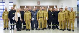 Grupowe zdjęcie funkcjonariuszy PSP oraz Straży Marszałkowskiej (15 osób) z okazji zakończenie szkolenia w towarzystwie Komendanta Centralnej Szkoły PSP, Zastępcy Komendanta CS PSP, kobiety oraz czterech funkcjonariuszy CS PSP