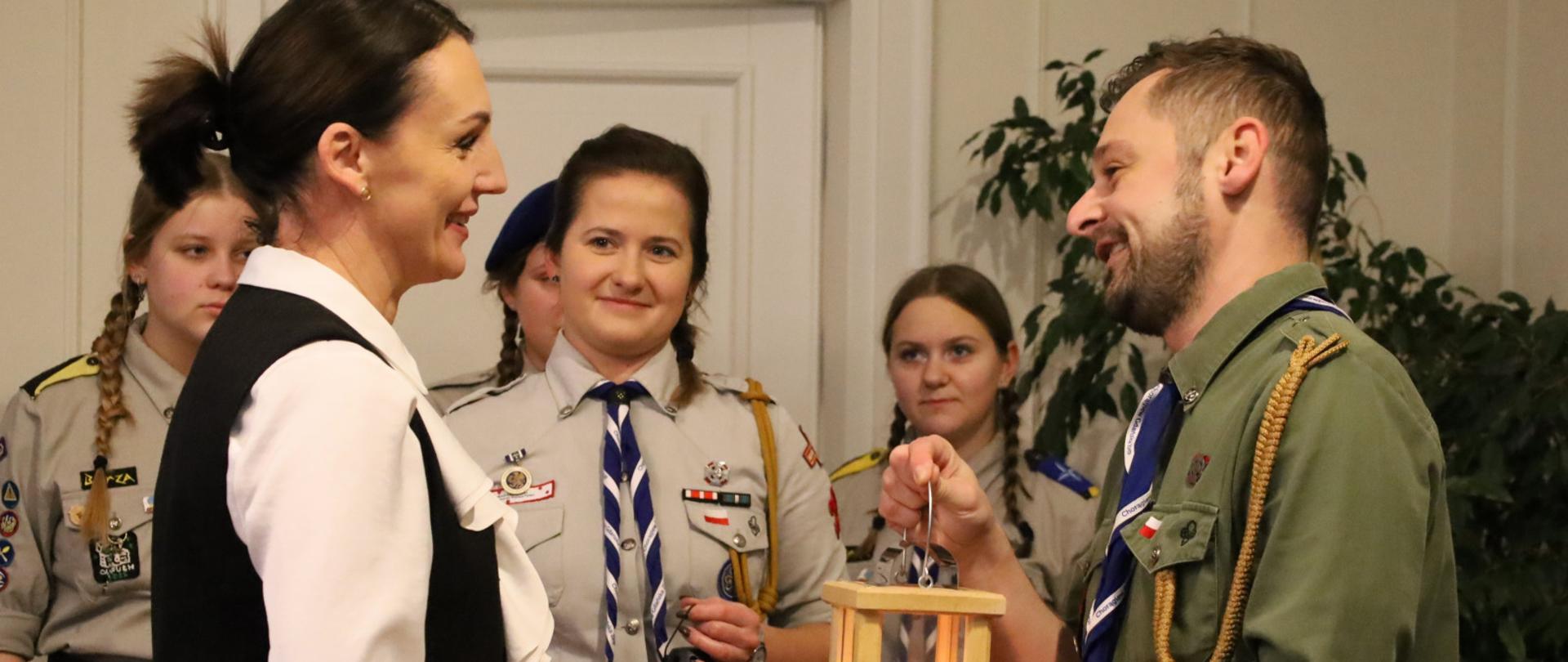 harcerz podaje światełko betlejemskie kobiecie (wojewodzie)