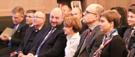 Na zdjęciu uczestnicy konferencji w pierwszym rzędzie. minister rozwoju W centralnej części Jadwiga Emilewicz oraz wicepremier, minister gospodarki i zdrowia Wielkiego Księstwa Luksemburga Etienne Schneider (uśmiechają się do siebie).
