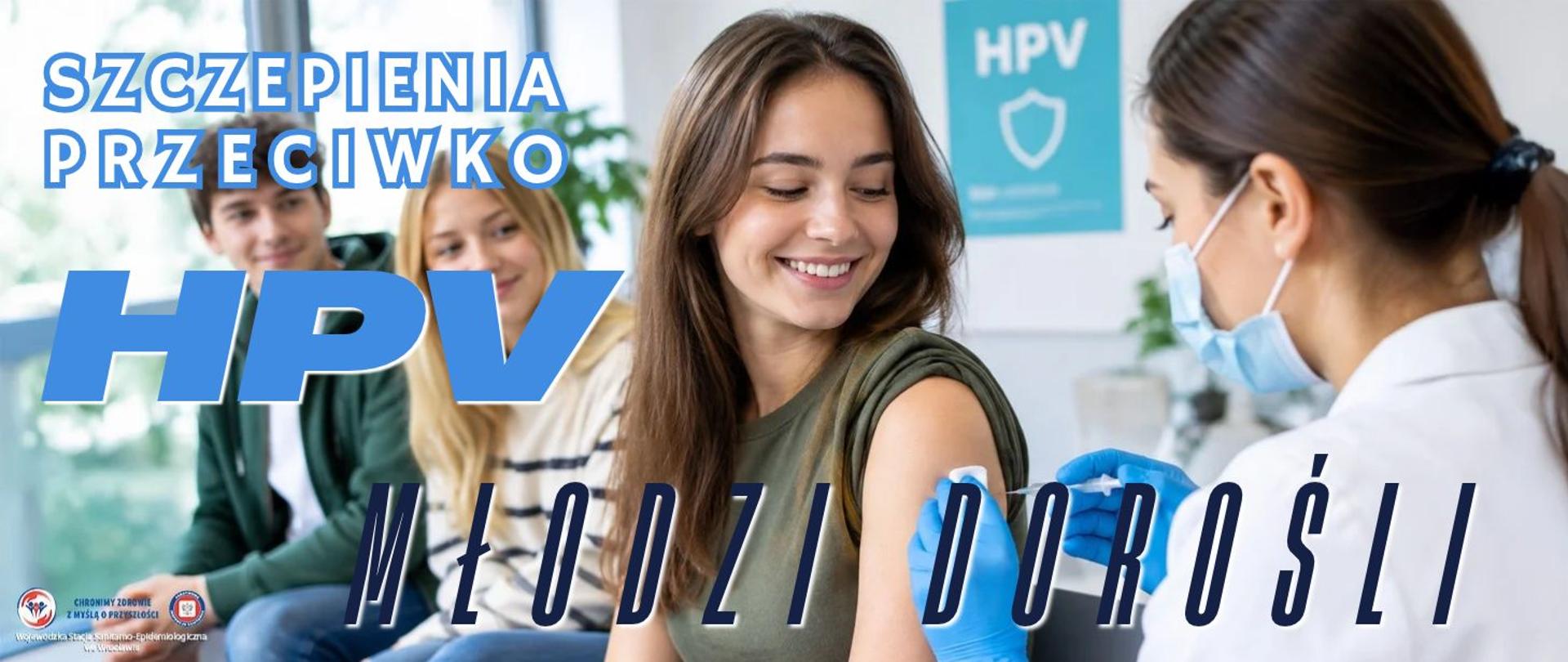 Grupa młodych osób siedząca w oczekiwaniu na szczepienie. Na pierwszym planie osoba podaje innej oczekującej osobie szczepionkę w ramię