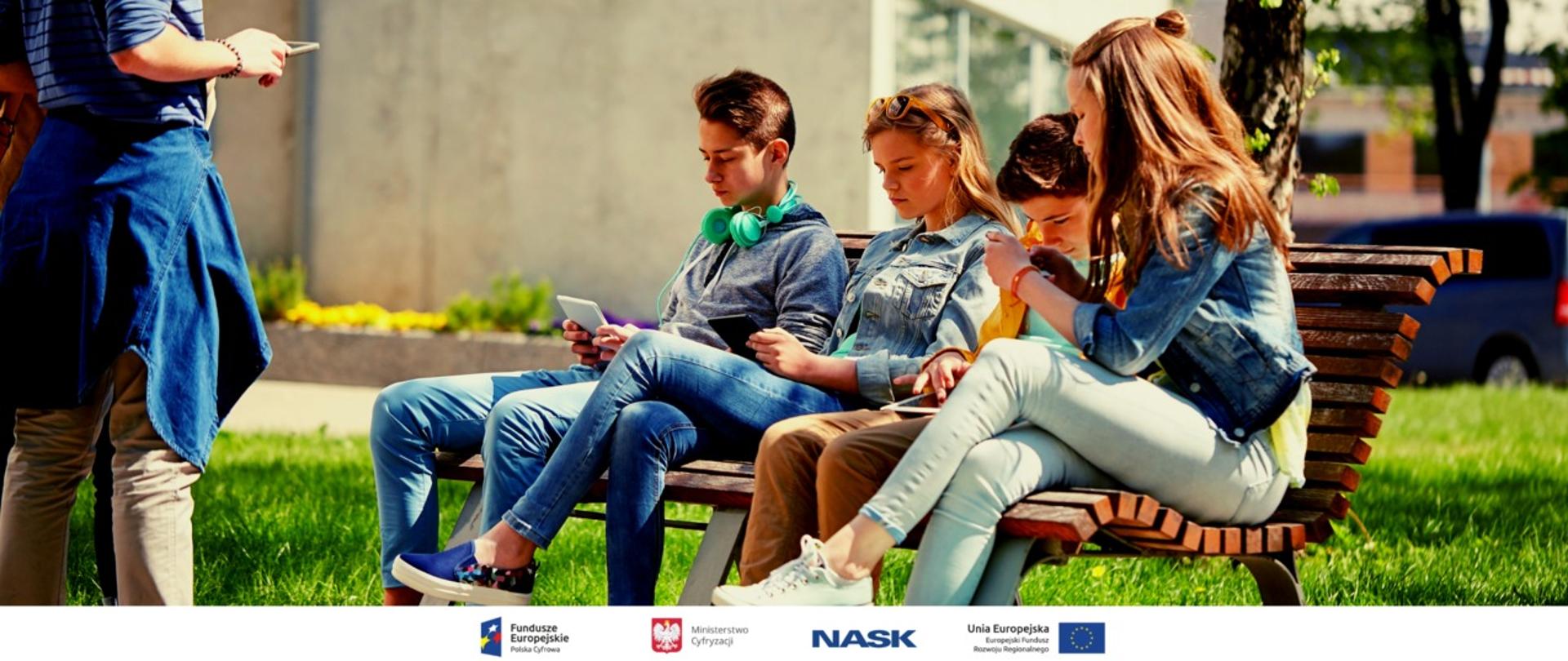 grupa nastolatków siedzi na ławce, trzymają telefony w rękach