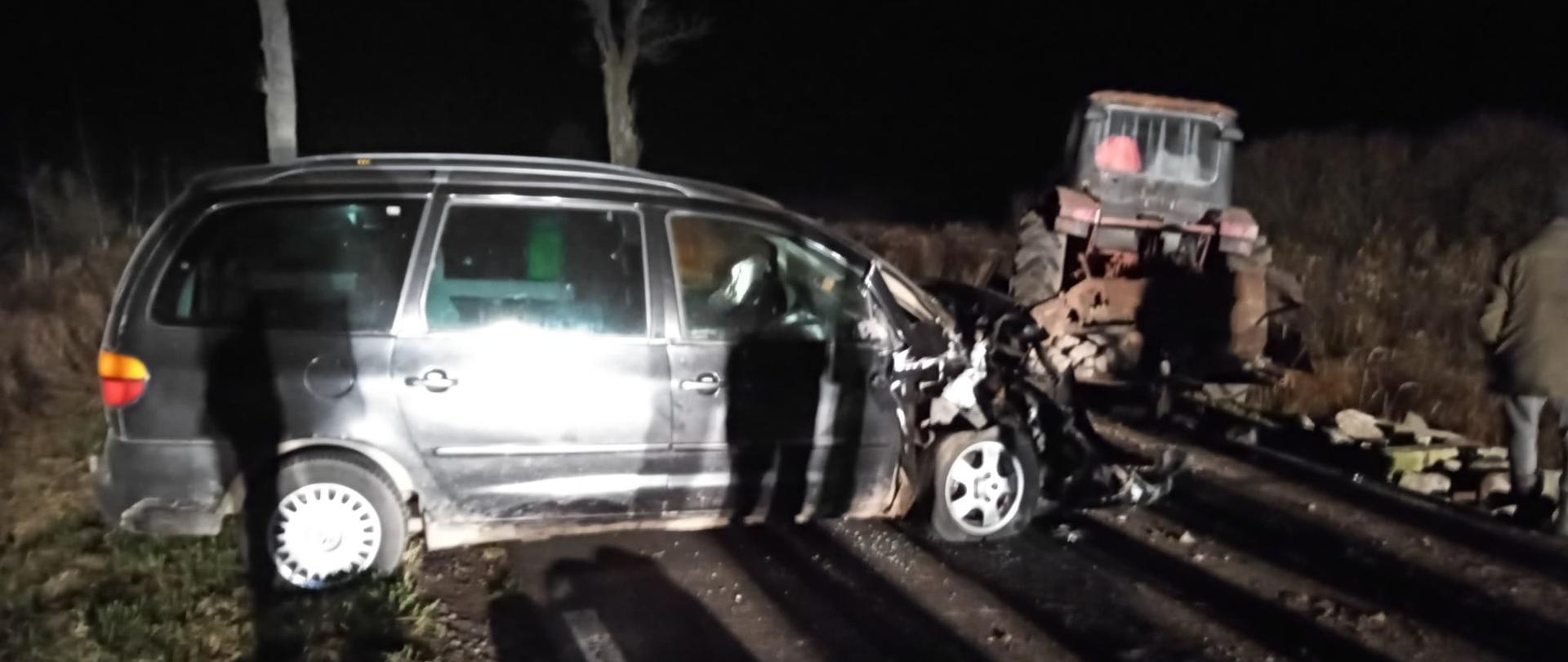 Na zdjęciu widnieje rozbity samochód osobowy i ciągnik rolniczy po wypadku. 