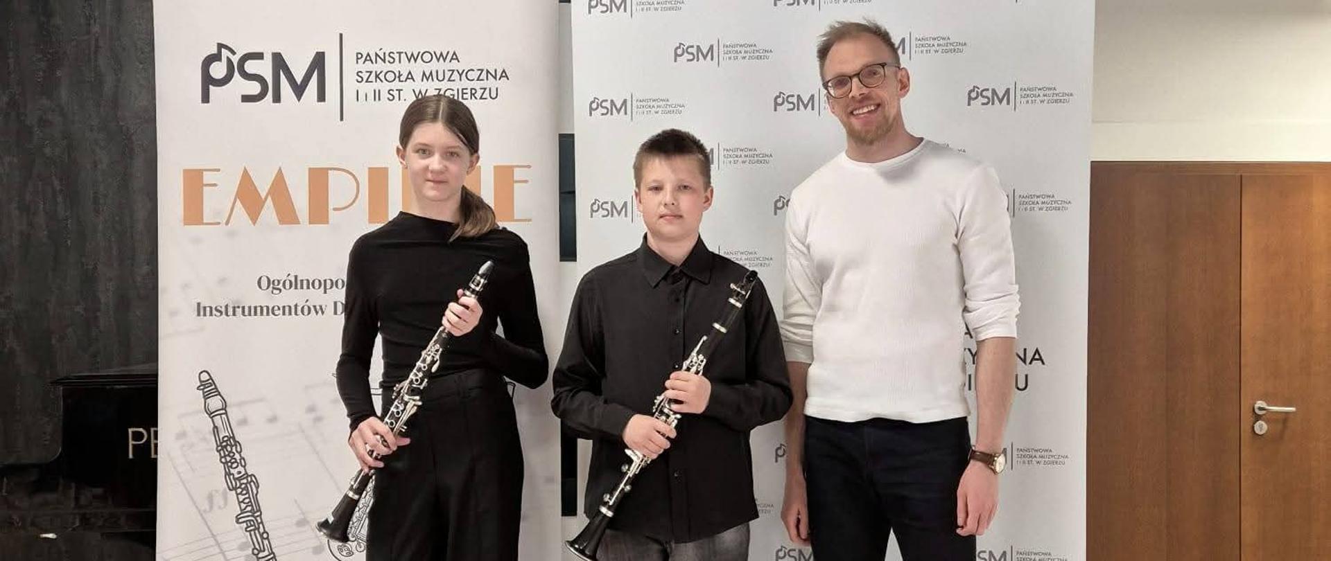 zdjęcie przedstawiające uczniów z klasy klarnetu pana Miłosza Wojcieszaka - Hannę Ratajczak oraz Maksymiliana Czaplińskiego na Ogólnopolskim Festiwalu Instrumentów Dętych Drewnianych EMPIRIE 2026, odbywającym się w Państwowej Szkole Muzyczne I i II stopnia w Zgierzu