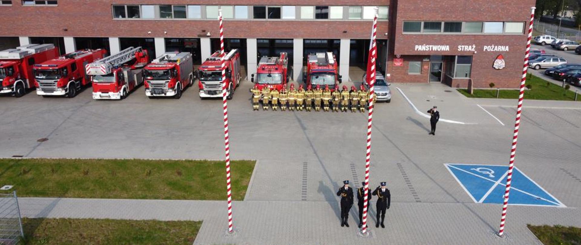 Strazacy z flaga przed Komenda PSP