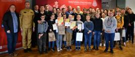Na zdjęciu widzimy uczestników Ogólnopolskiego Turnieju Wiedzy Pożarniczej „Młodzież Zapobiega Pożarom” pozujących do zdjęcia grupowego.