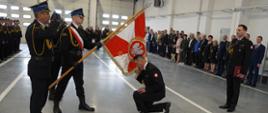 Ceremoniał powitania ze sztandarem Komendy Powiatowej Państwowej Straży Pożarnej w Opocznie, nowy Komendant oddaje honor poprzez ucałowanie sztandaru w tle zgromadzeni goście