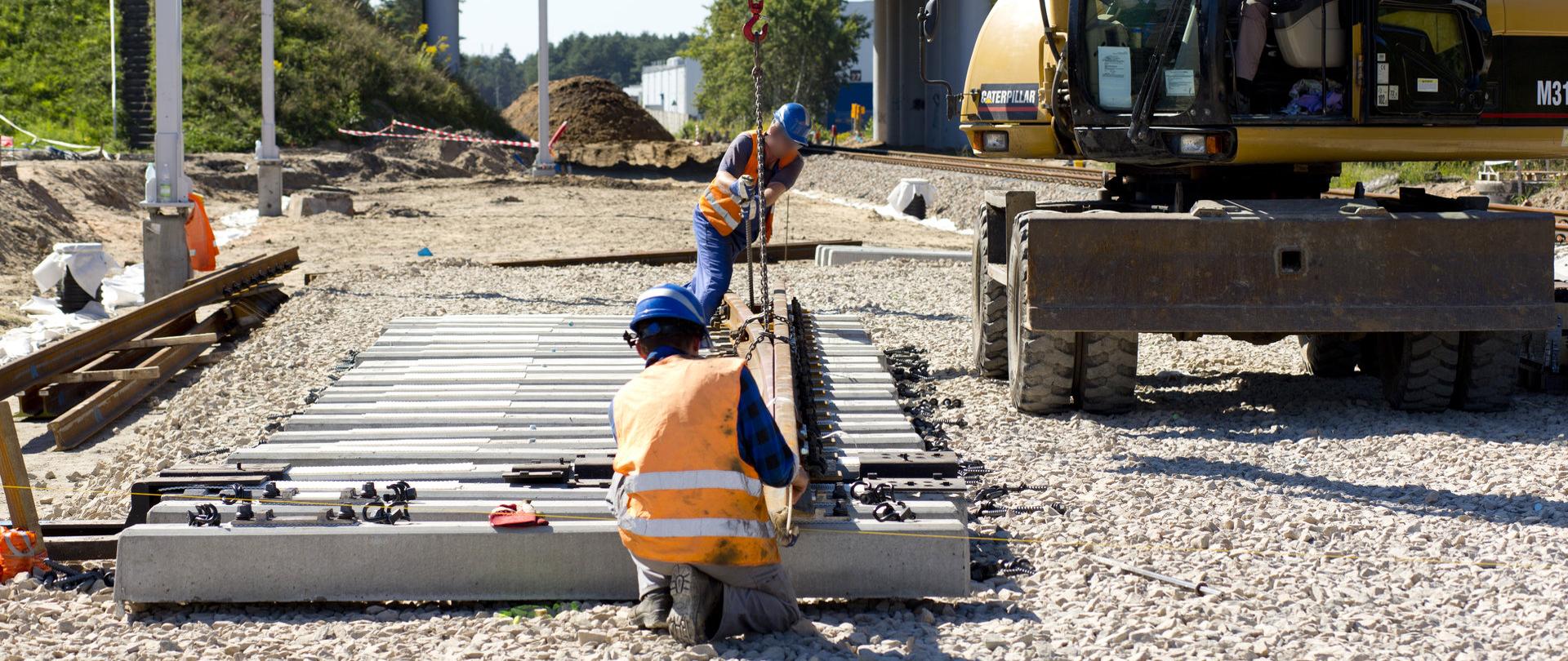 Prace prowadzone na stacji Siewierz - pracownicy i maszyny układają nowy tor