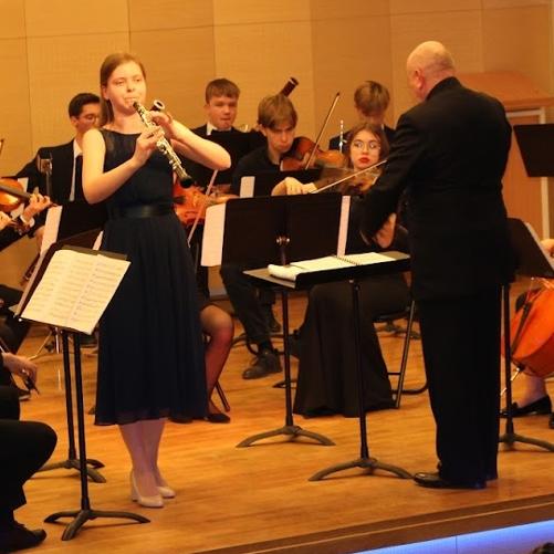 Grafika przedstawia osoby grające w orkiestrze symfonicznej