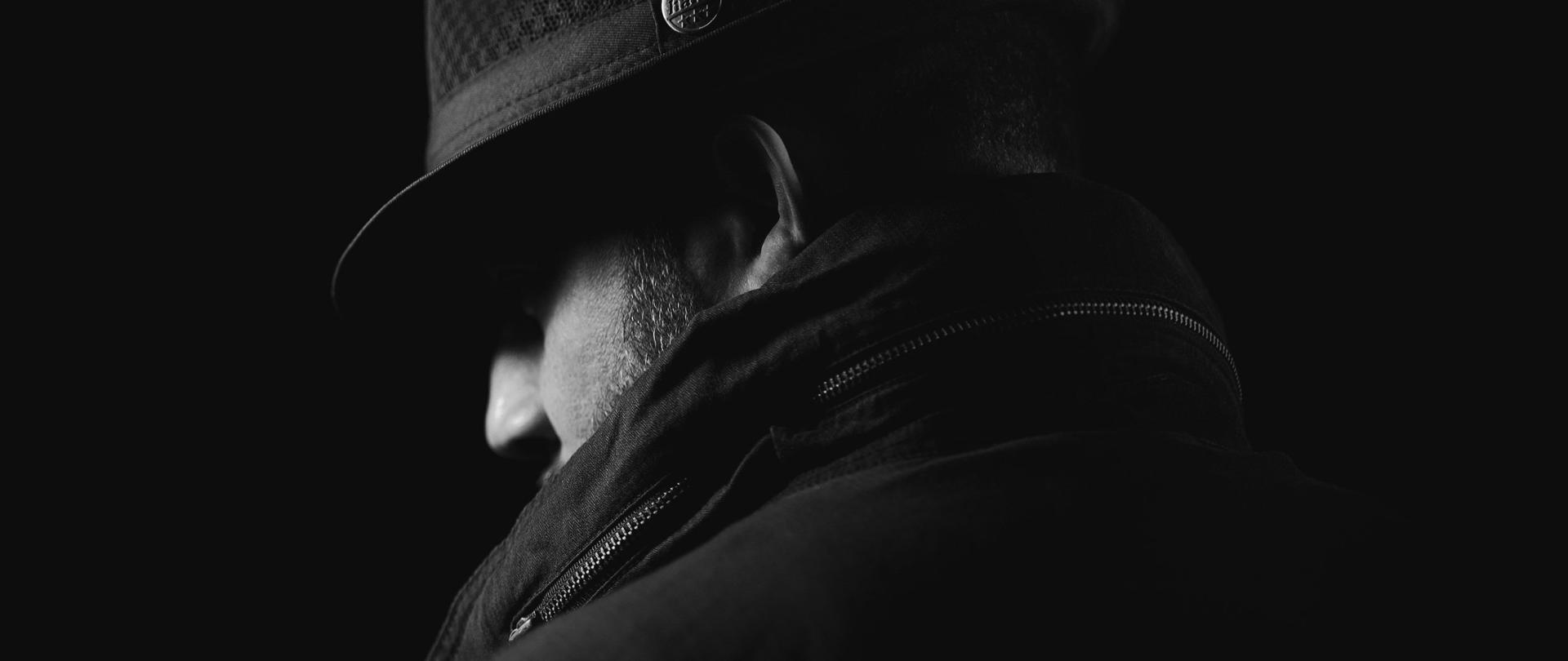 Plakat cichy zabójca. Na zdjęciu tajemnicza postać. Zdjęcie czarno-białe