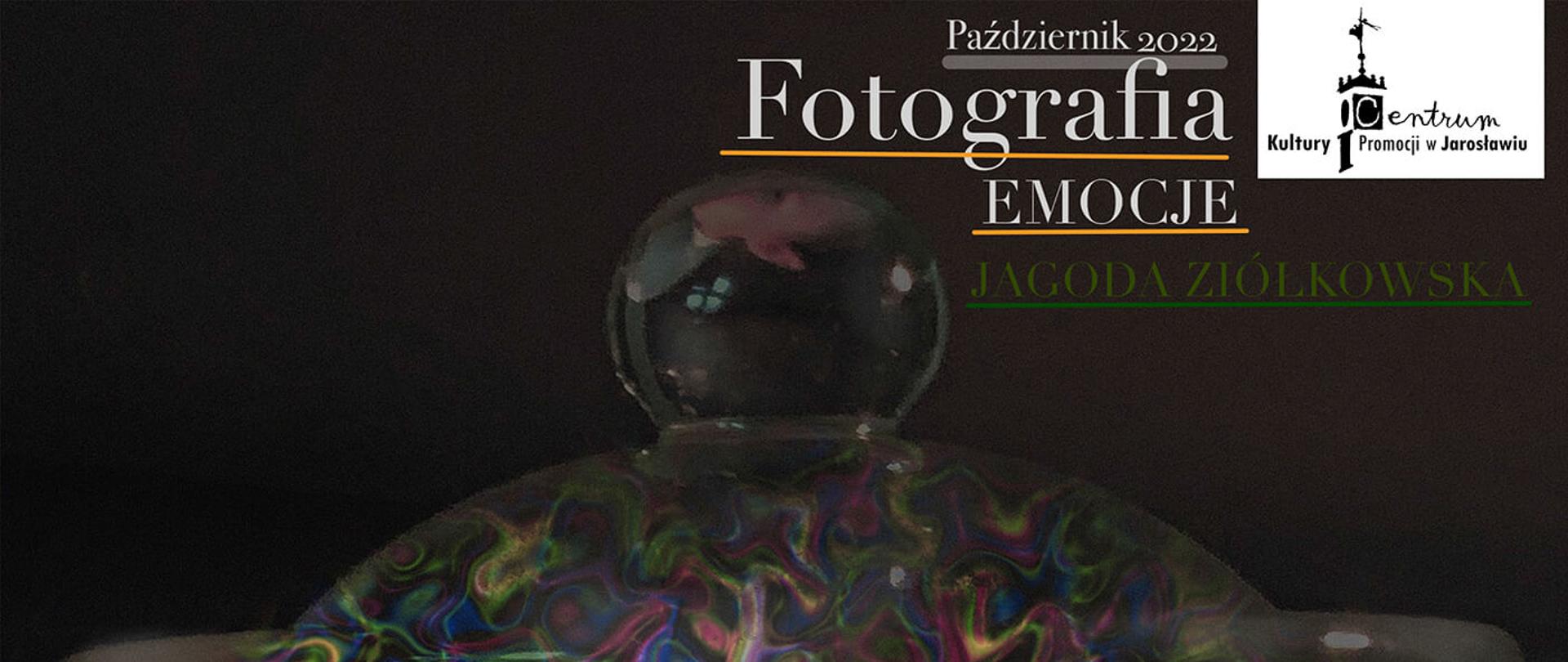 Plakat wystawy fotograficznej, na czarnym tle został centralnie umieszczony szklany słój w którym znajdują się wielobarwne elementy graficzne. Góra plakatu posiada szczegółową informację tekstową o wystawie.