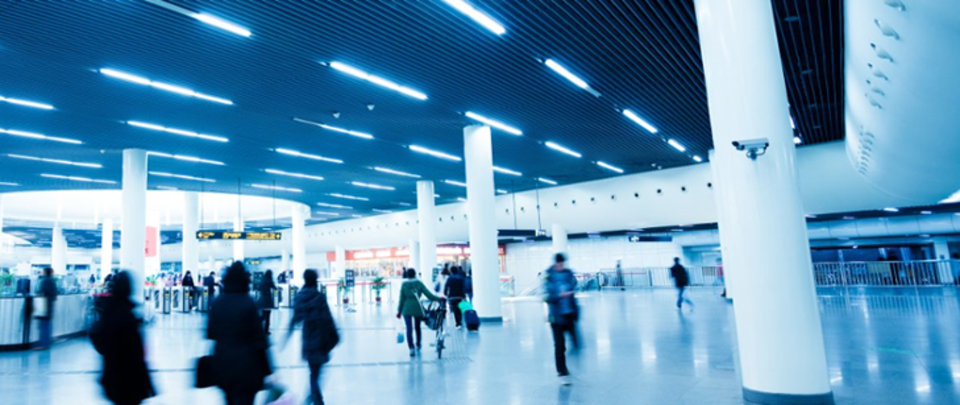 Zdjęcie przedstawia terminal lotniska i pasażerów 