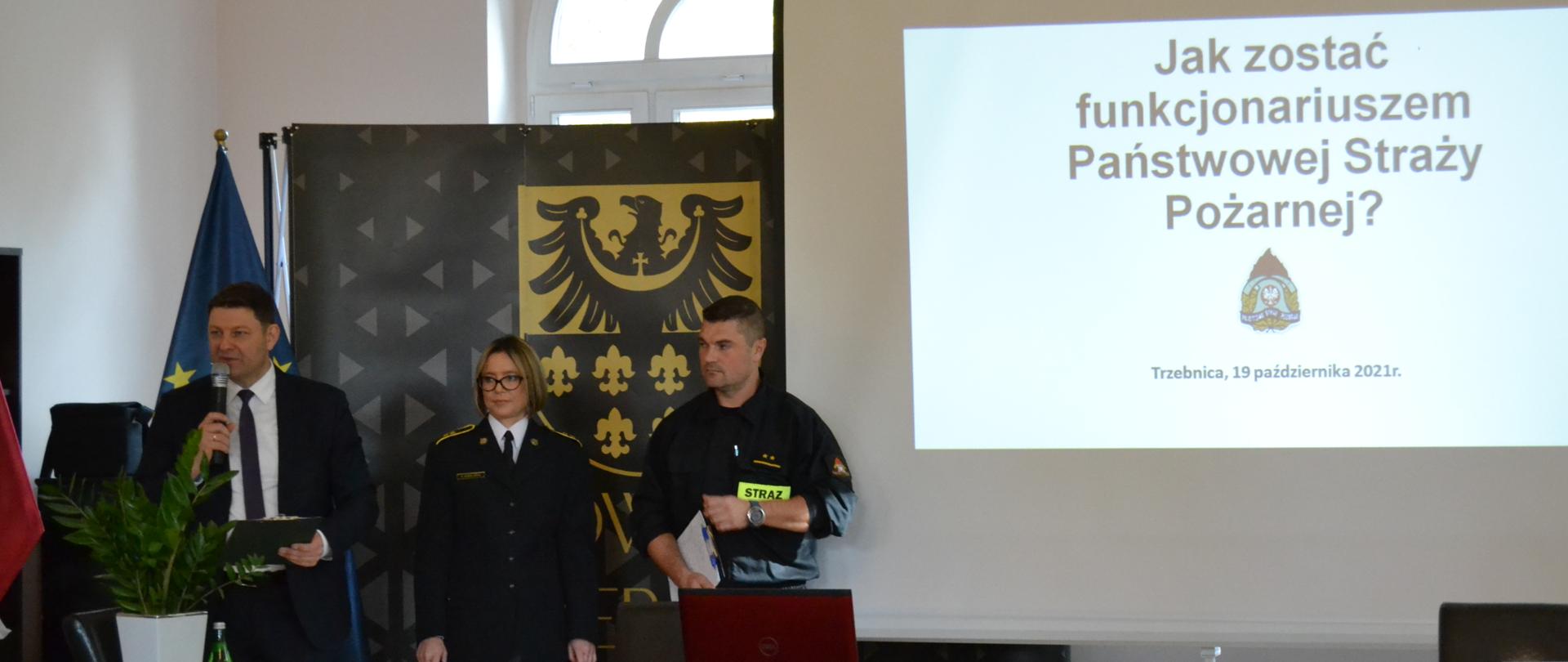 Dwoje funkcjonariuszy z Dyrektorem Powiatowego Urzędu Pracy w sali wykładowej