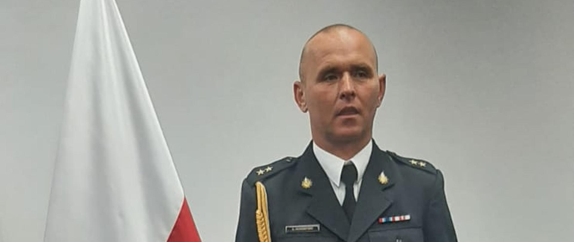 Na zdjęciu widoczny strażak przy fladze państwowej