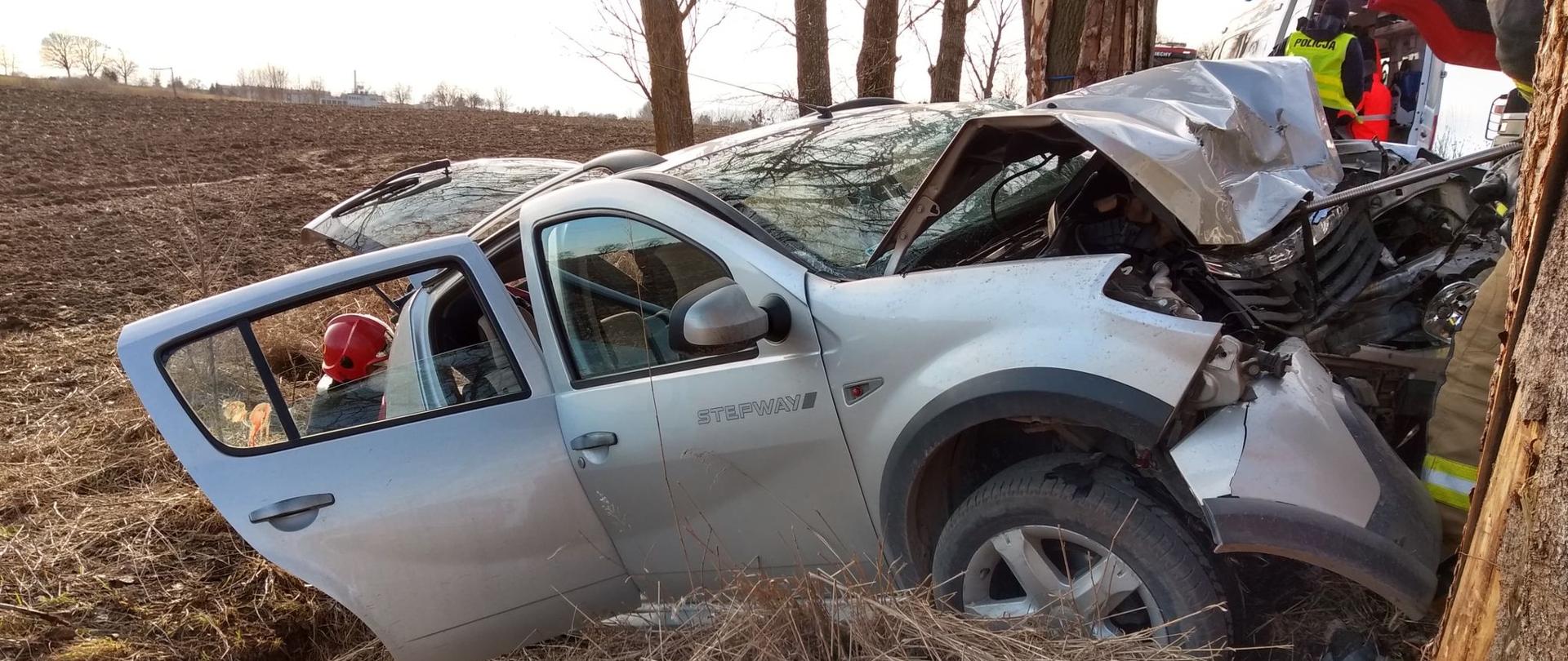 Na zdjęciu widać samochód marki Dacia Sandero znajdujący się na skarpie drogi. Po prawej stronie widać uszkodzenia przodu pojazdu.