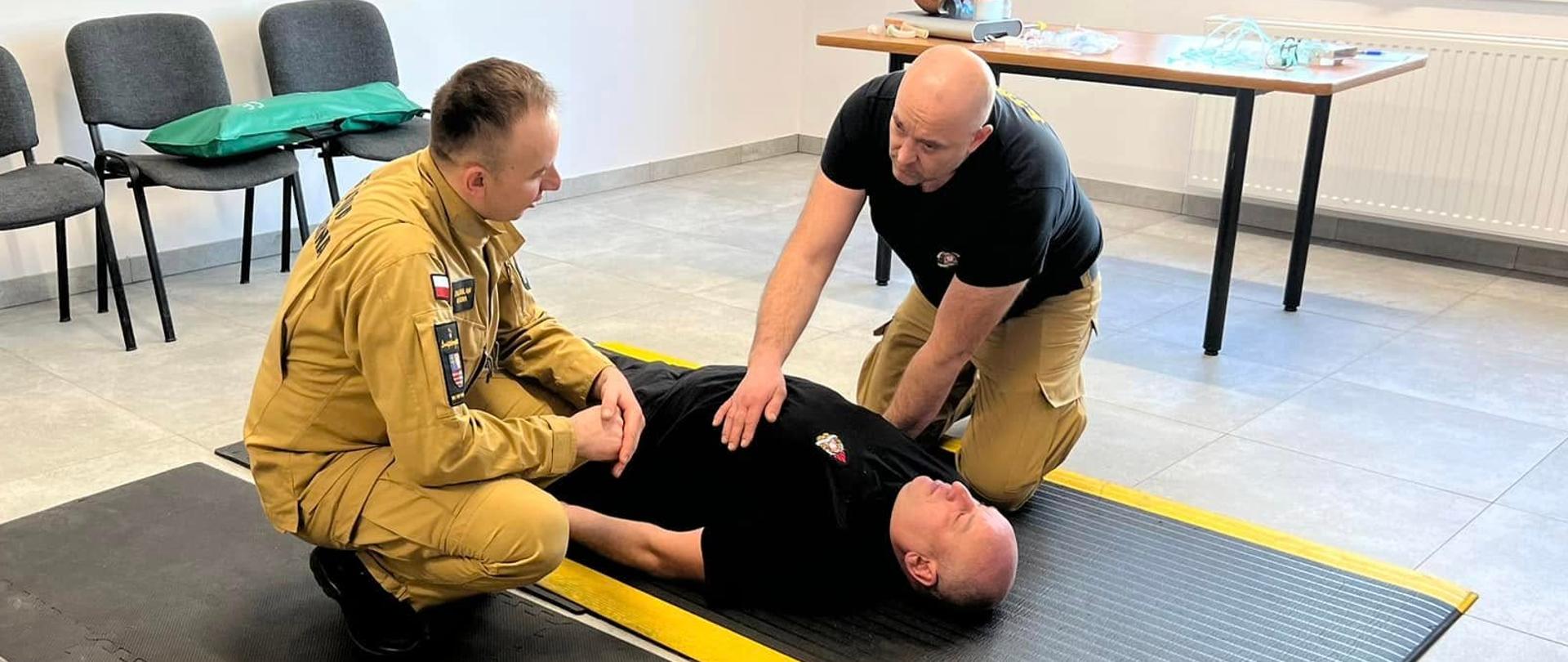 Strażak przeprowadza badanie urazowe