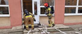 Rota strażaków przygotowująca się do wejścia do budynku szkoły
