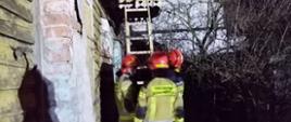 Strażacy przystawiają drabinę do budynku