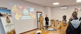 Funkcjonariusze i młodzież podczas omawiania pierwszej pomocy