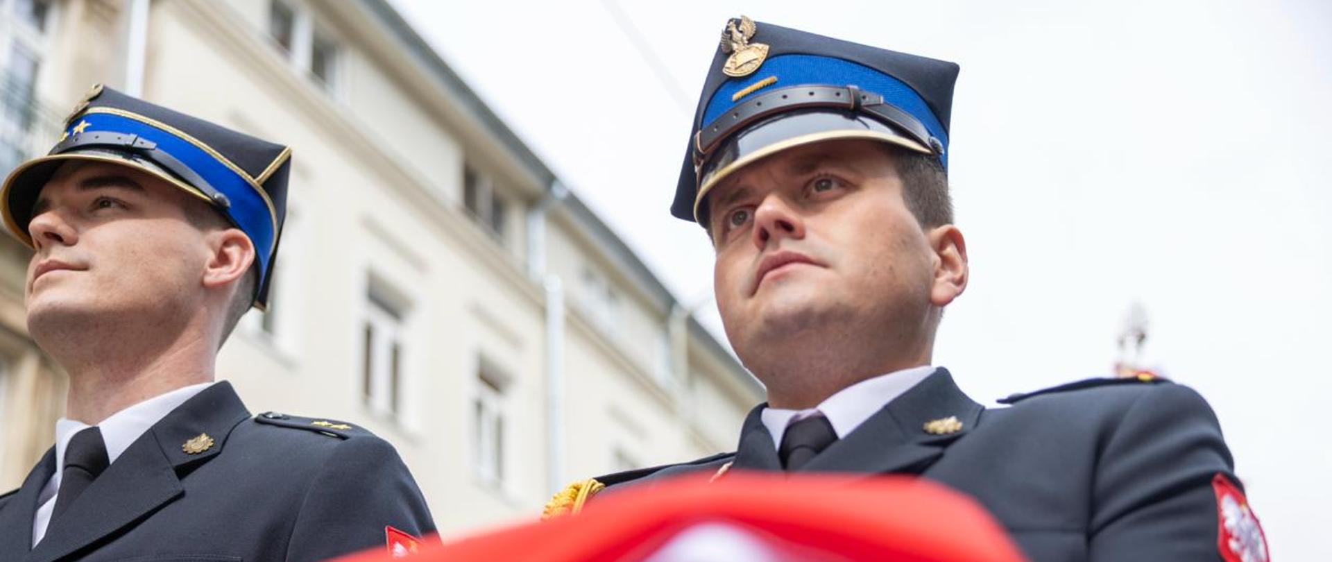 Strażacy trzymający flagę Polski 