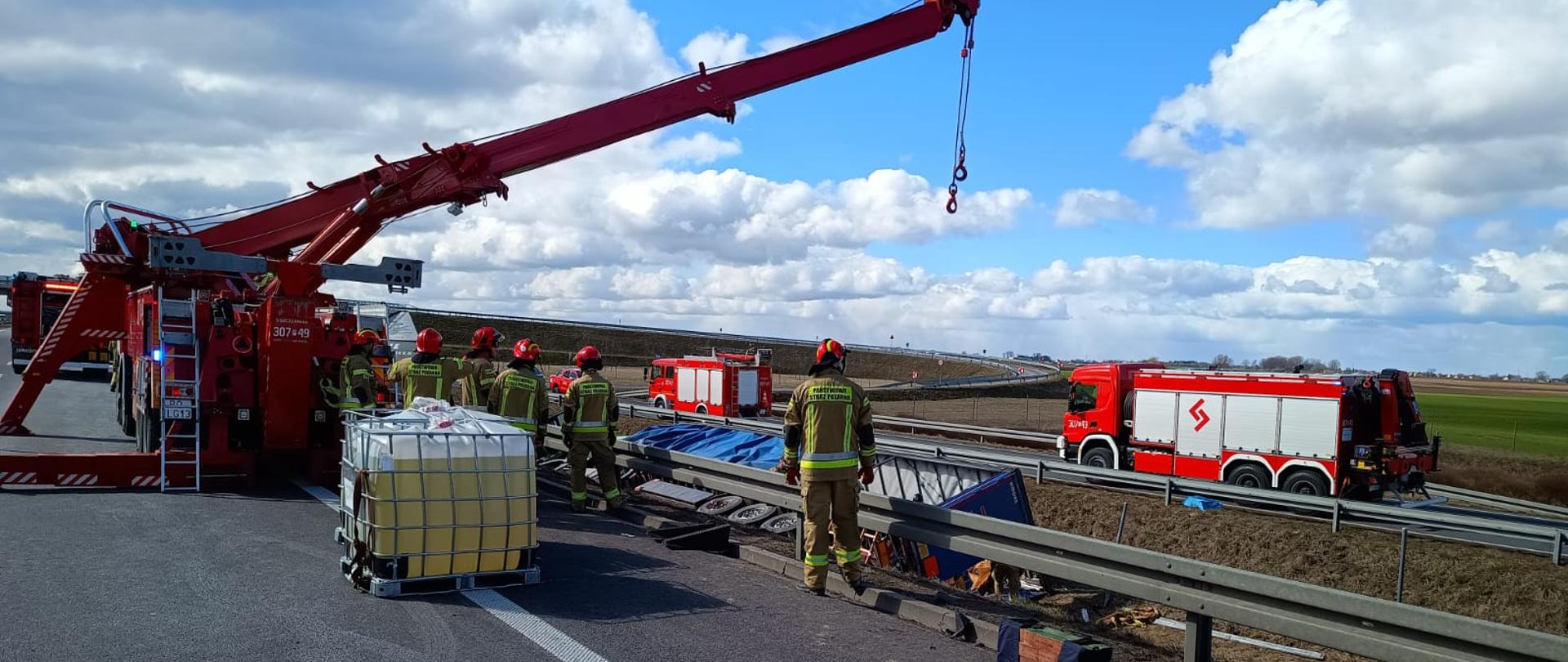 Na zdjęciu widać samochód specjalny Rotator, który wyciąga pojemniki o pojemności 1000 l z uszkodzonego samochodu ciężarowego biorącego udział w kolizji.