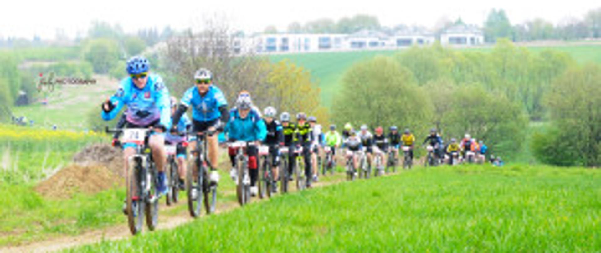 Zdjęcie przedstawia kolarzy rywalizujących na trasie wyścigu kolarskiego MTB