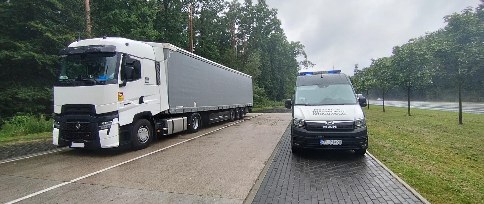 Na zdjęciu widać radiowóz i pojazd ciężarowy z naczepą.