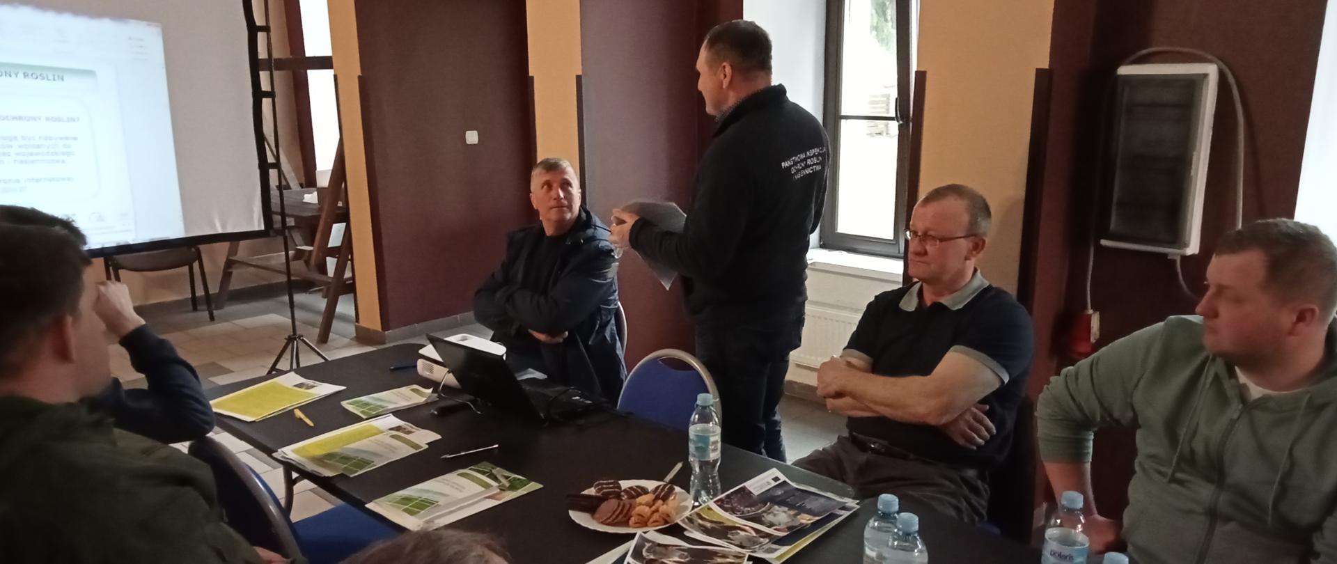 Uczestnicy szkolenia siedzą na sali konferencyjnej. Inspektor stoi na środku sali bokiem do słuchaczy i
prowadzi wykład.