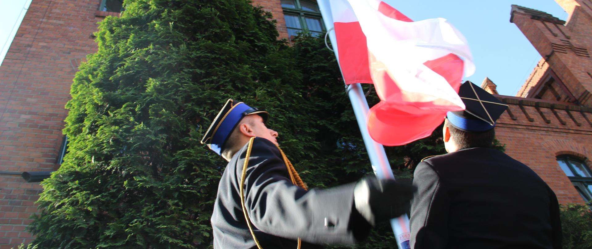 Na zdjęciu poczet flagowy strażaków PSP dokonuje wciągnięcia flagi na maszt przy obiekcie strażnicy - KW SPP w Toruniu.