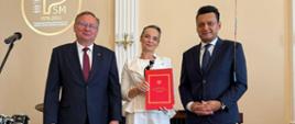 Posłowie Przemysław Witek i Andrzej Gawron oraz Pani Dyrektor Sonia Wachowska na scenie w sali koncertowej podczas Uroczystego Koncertu Absolwentów