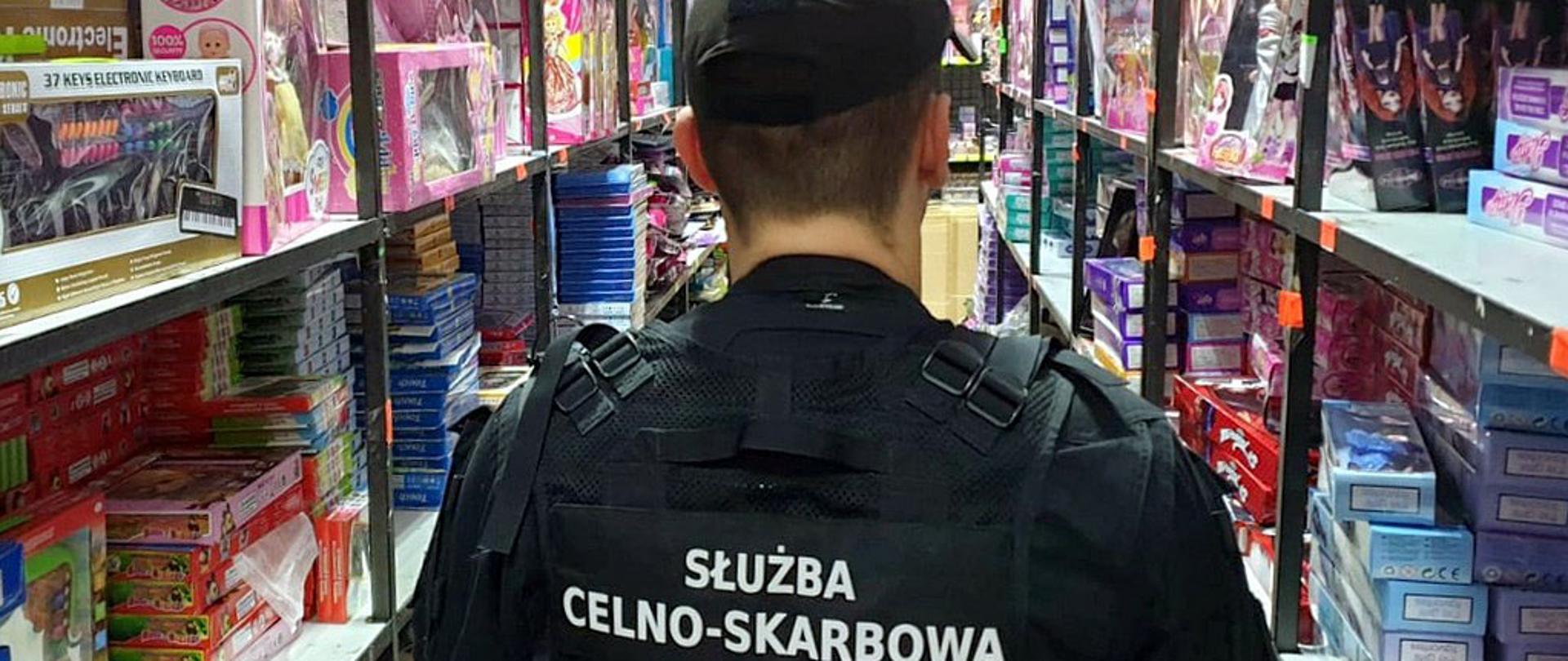 Funkcjonariusz Służby Celno-Skarbowej pomiędzy regałami z podrobionymi zabawkami