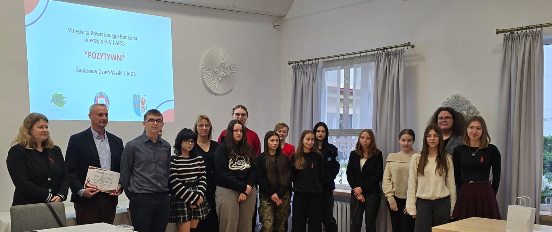 Organizatorzy i uczestnicy konkursu wiedzy "Pozytywni" razem pozują do zdjęcia zbiorowego.