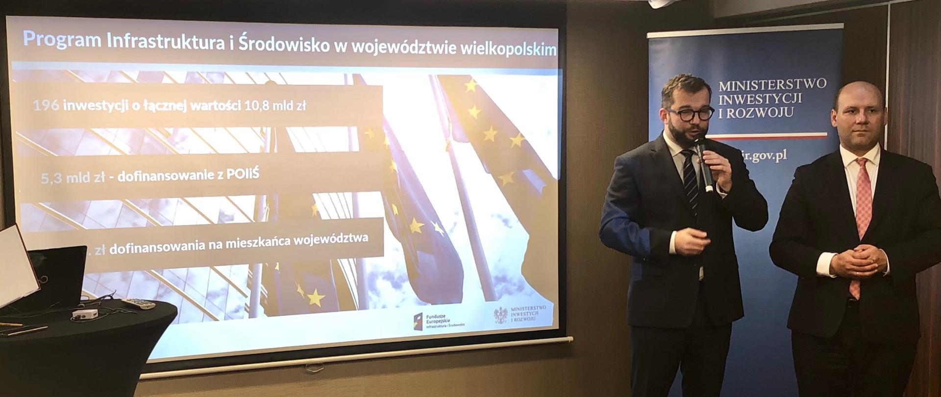 przed prezentacją stoi i mówi do mikrofonu wiceminister Grzegorz Puda