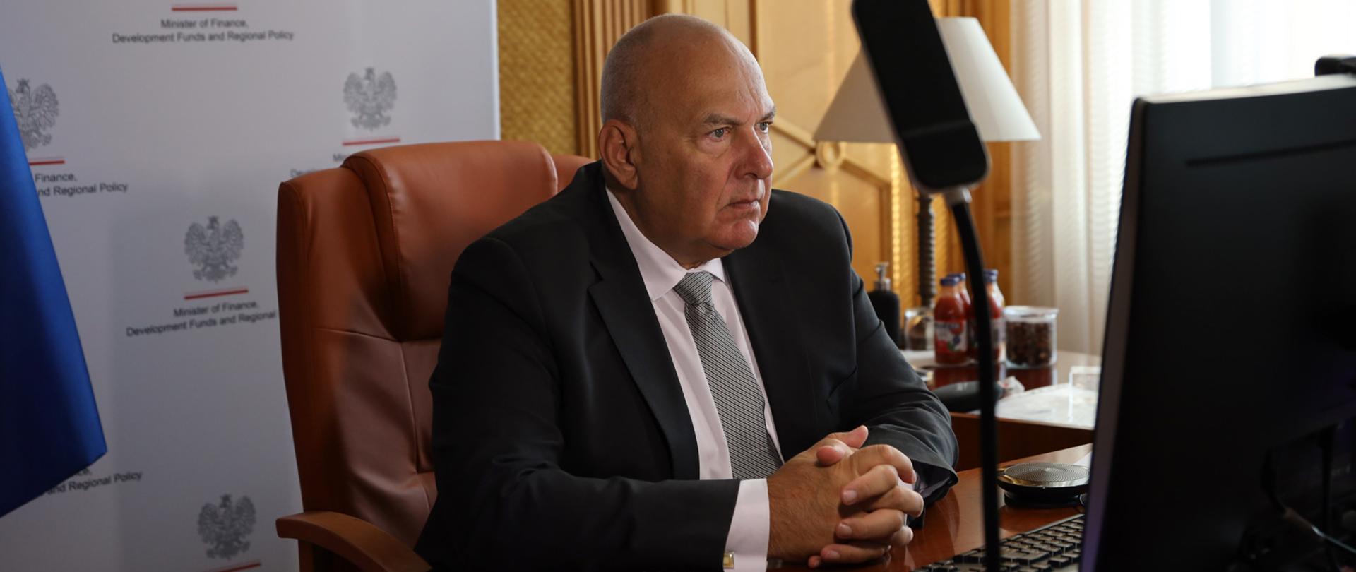 Minister Tadeusz Kościński na tle banera MF podczas spotkanie ministrów finansów krajów CESEE