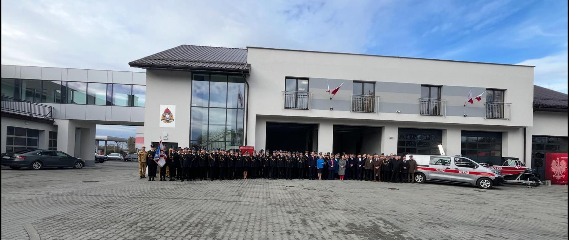 na zdjęciu widoczny nowo oddany budynek garażowo - warsztatowy, przed budynkiem widoczni uczestnicy uroczystości